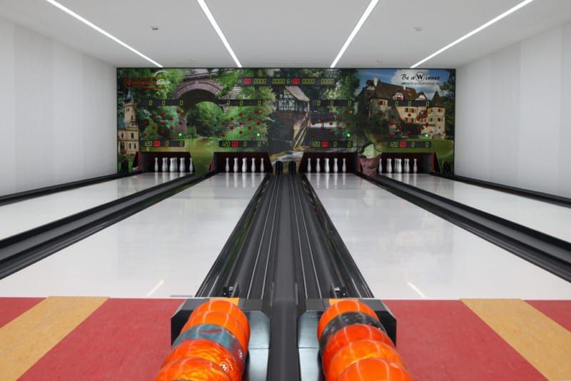 Kegelbahn mit orangefarbenen Winner-Kugeln im Kugelrücklauf